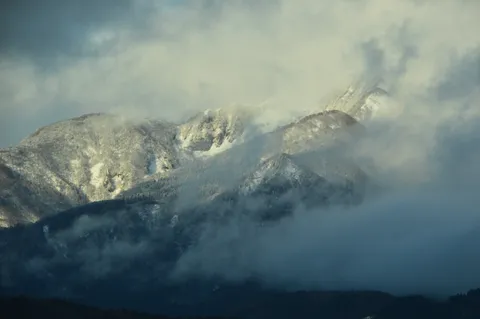 雲間に浮かぶ雪化粧の峰