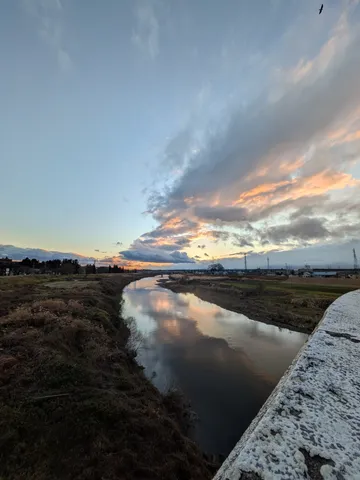 夕焼け空の川面、映る光景