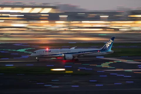 光の軌跡とANA機、滑走路の躍動