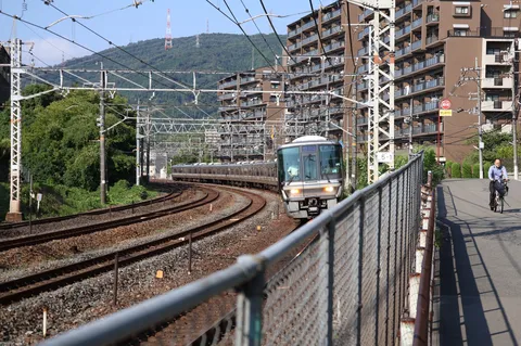 カーブを曲がる列車と日常の風景