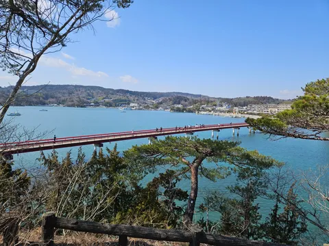 穏やかな湾に架かる朱色の橋