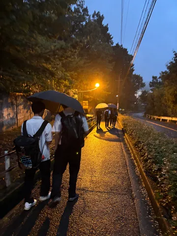 雨の路地に浮かぶ灯りと人影