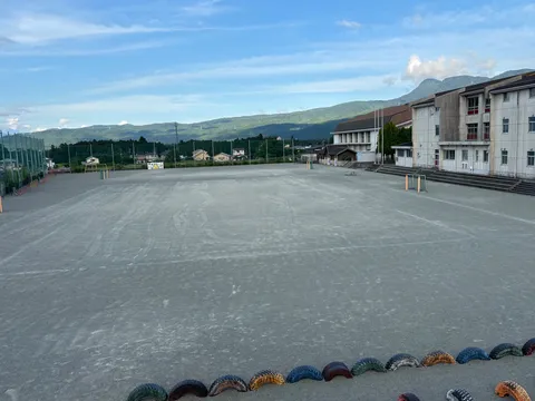 広がる大地と山々、静かな学校の風景