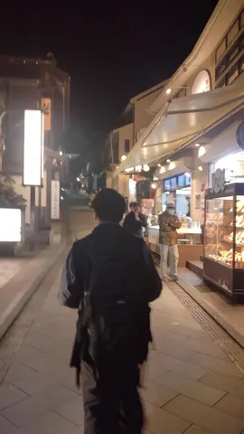 夜の商店街、人影と灯り