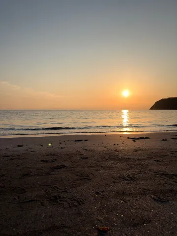 水平線に沈む太陽と砂浜