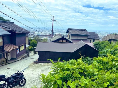 坂道を下るバイクと街並み