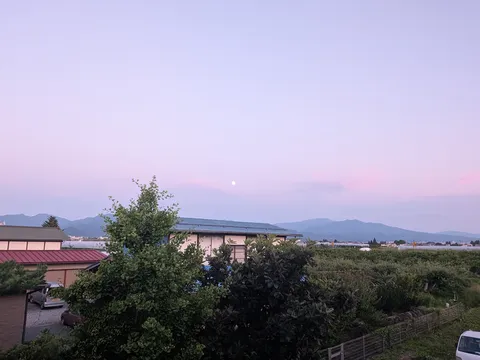 薄明かりに浮かぶ月と山々