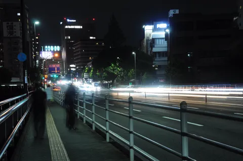 都会の夜、光の残像が流れる