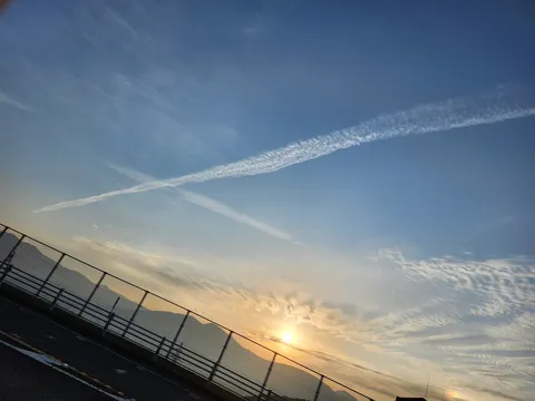 空に描かれたX印、夕焼けに染まる道
