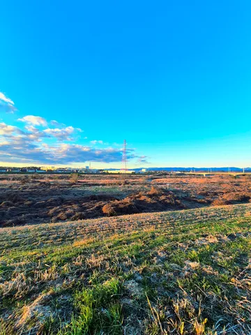夕暮れ時、鉄塔がそびえる広大な土地