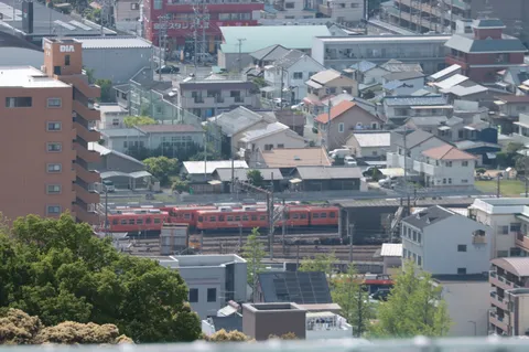 都市風景と連なるオレンジの電車