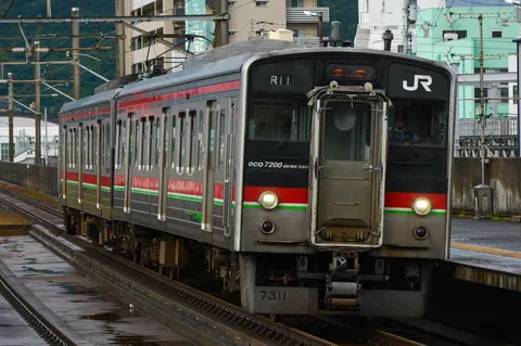 静かにレールを滑る、緑と赤の車両