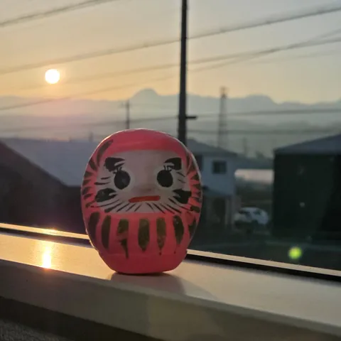朝日を浴びる達磨さんの決意