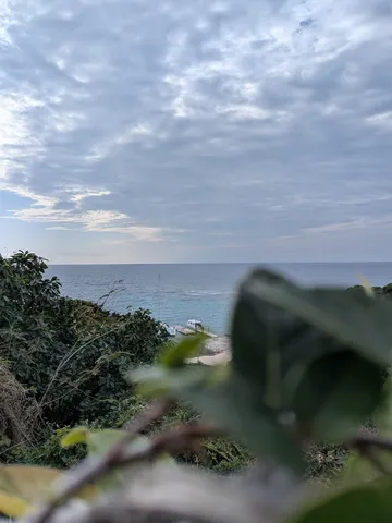 雲間から覗く、青い海と緑のコントラスト