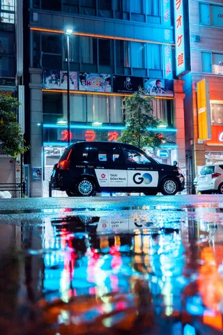 ネオンを運ぶ雨夜のタクシー