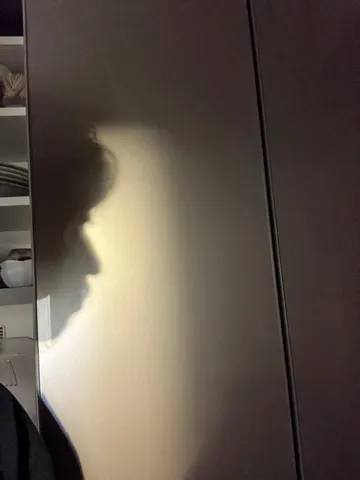 壁に映る横顔の影