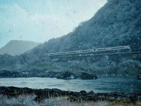 雪化粧の山を走る銀色の列車