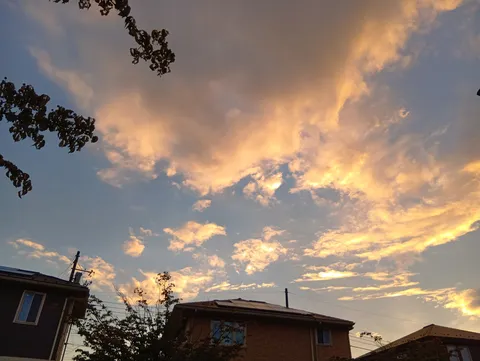 夕焼けに染まる雲と住宅街