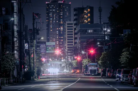 夜の街に灯る赤信号の影