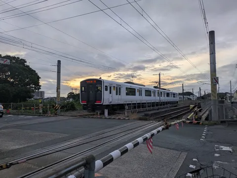 夕暮れの踏切、列車の静かなる邂逅