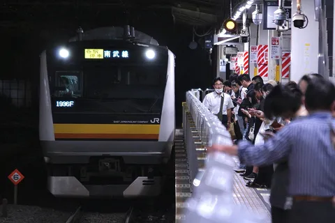 都会の夜、電車の光跡の交差点