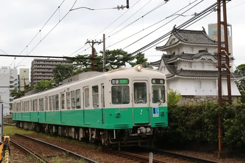 城下を走る緑の電車