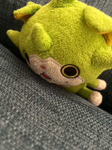 ソファでくつろぐ緑のぬいぐるみ