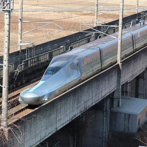 銀色の流線形、高架を走る新幹線