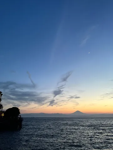 水平線に沈む夕日と月