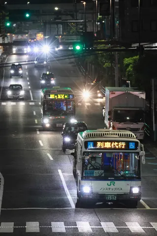 夜の路上を走る列車代行バス