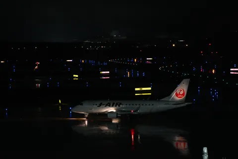 夜の空港、反射する光の道