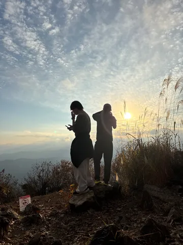 夕陽に照らされる山頂の二人