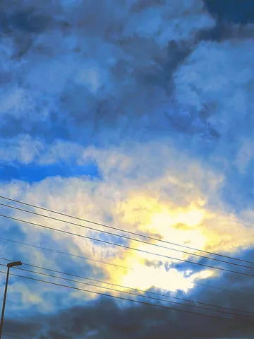 電線と黄金の雲のコントラスト