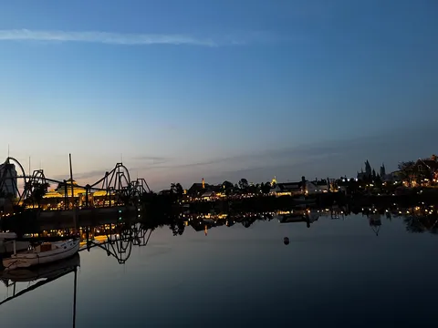 夜の水面に映る光の遊園地