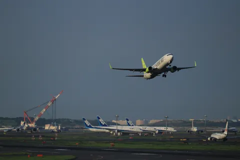 離陸する航空機とクレーン