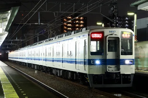 夜のホームを駆ける列車の灯り