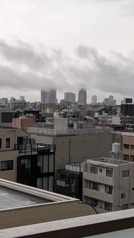 雨雲が包む都会の縁