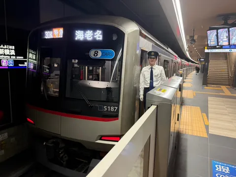 笑顔の乗務員と発車前の特急電車