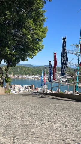 坂道の先、潮風と旗のコントラスト