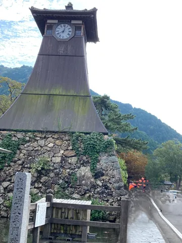 時を刻む古塔と新緑のコントラスト