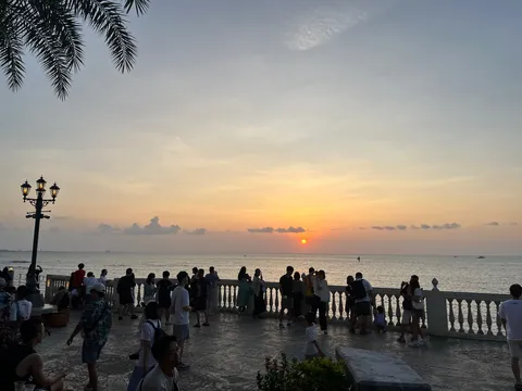 夕暮れの海辺、集う人々