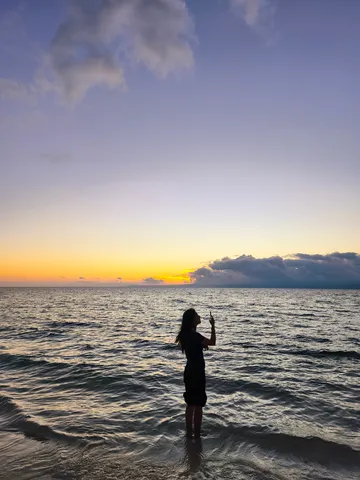 夕暮れの海辺、スマホで記録する瞬間