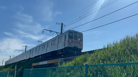 青空の下、線路を走る銀色の列車