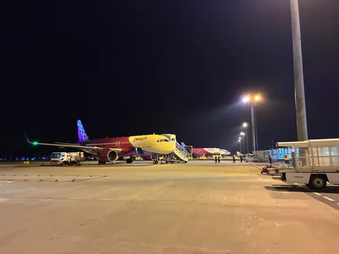 夜の空港に浮かぶ桃色の翼