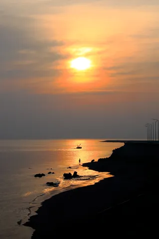 夕陽と影の静かな海辺