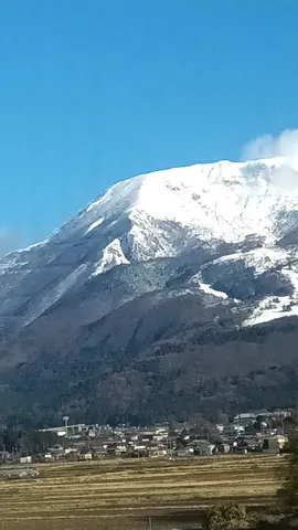 雪山見下ろす集落と田畑
