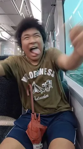 揺れる電車で、舌出しスマイル