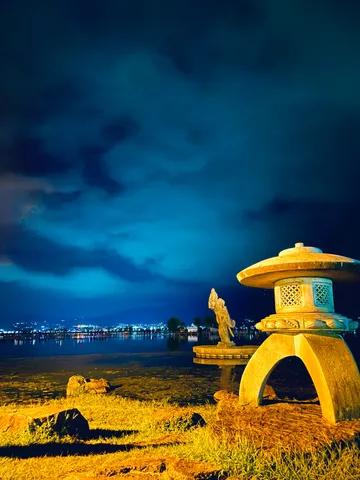 夜の湖畔、灯籠と水面の静寂