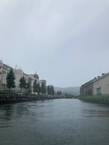雨の運河と傘の列