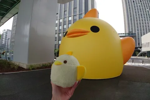 親子のひよこ、都会のビル街に立つ